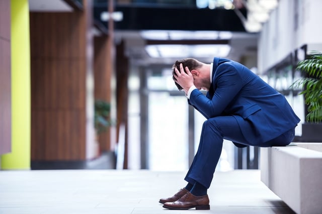 frustrated young business man working on laptop computer at office.jpeg